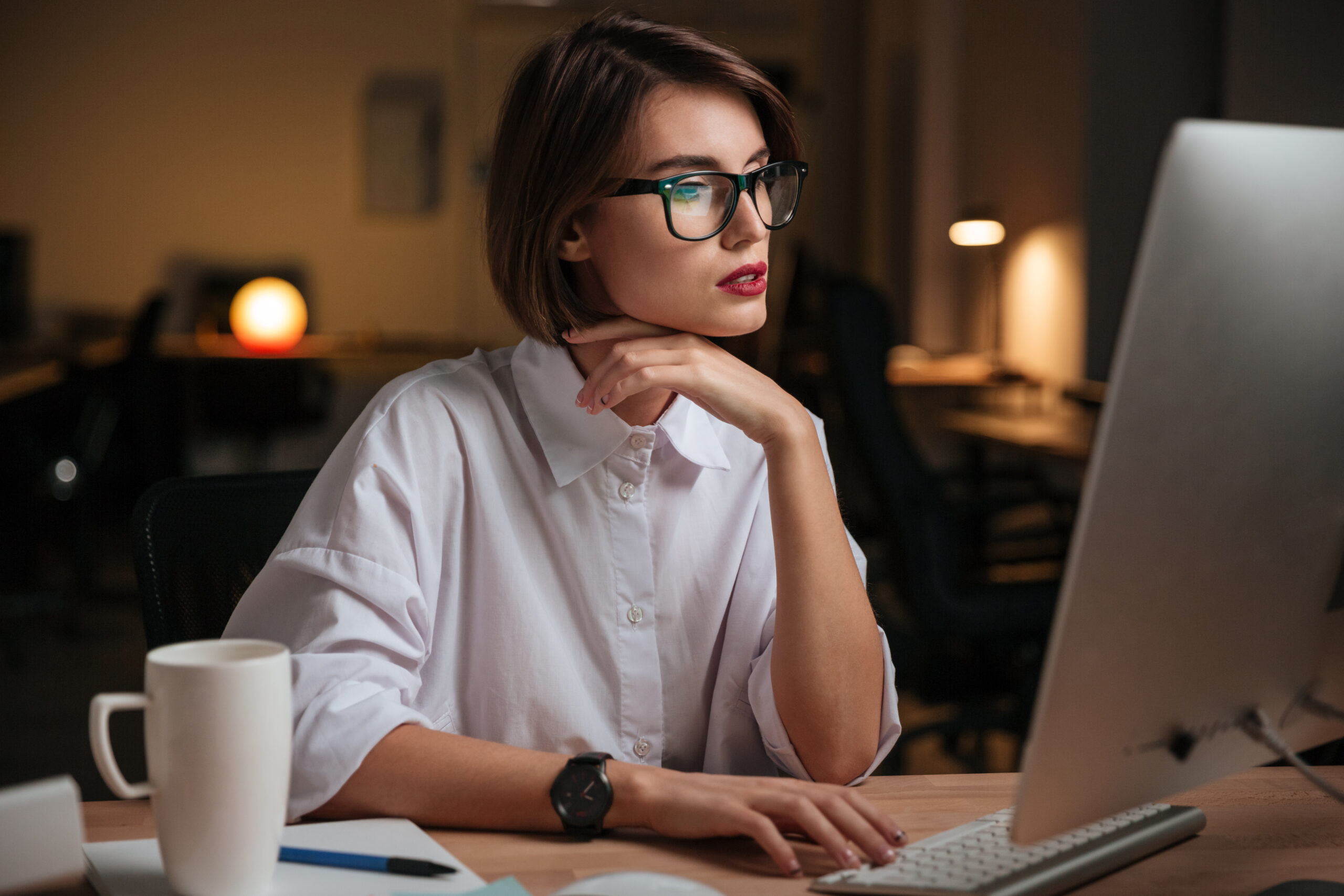 Serious, young businesswoman working at a computer in her office